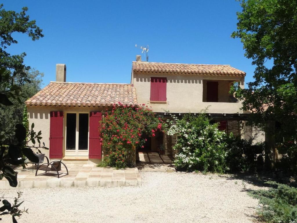 GramboisNice house with private pool in the Parc du Luberon, Grambois的一座有红白门和花的房屋
