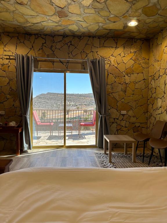 阿尔哈姆拉jabal shams view stay نزل إطلالة جبل شمس的一间卧室设有一张床和一个大窗户