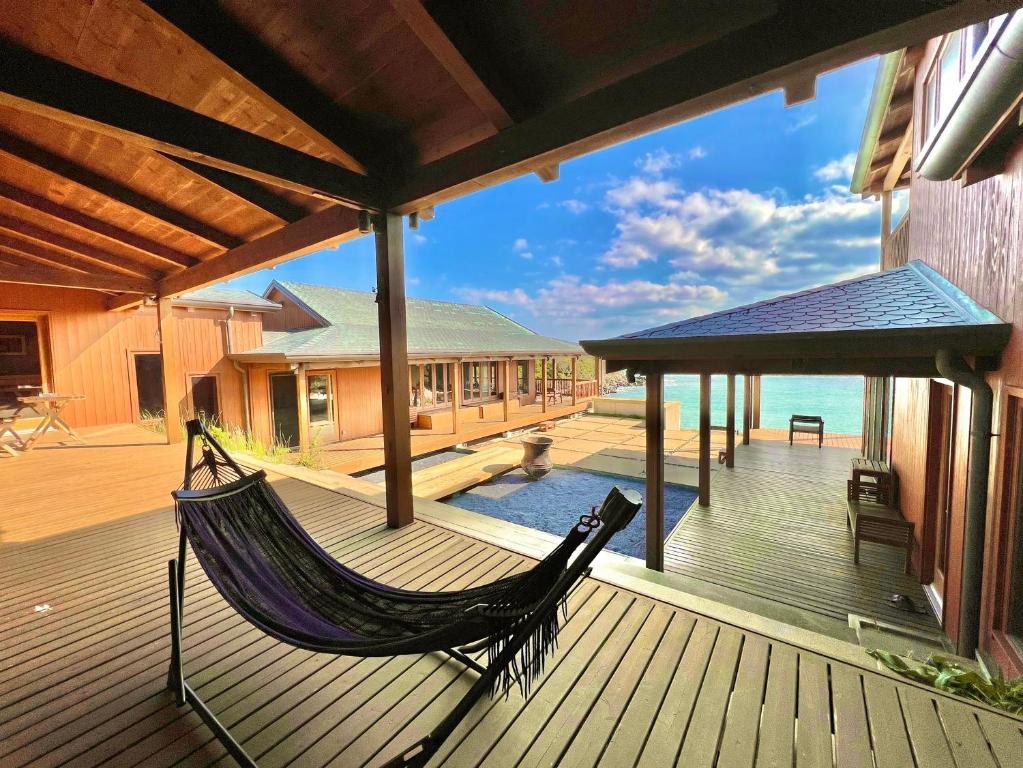 壹岐市Private beach retreat Resort villa iki by ritomaru的房屋甲板上的吊床