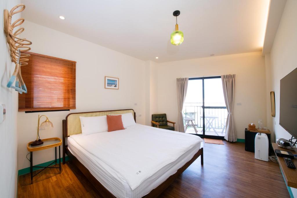 小琉球岛Lixia Hostel 立夏旅宿 的卧室设有白色的床和大窗户
