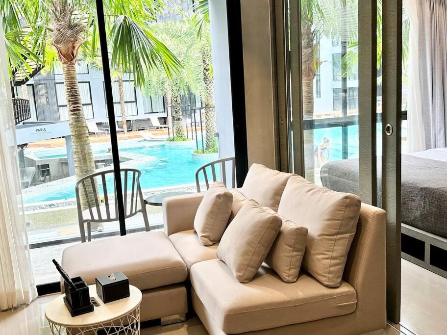 卡马拉海滩Kamala Beach Pool view Resort P15的带沙发的客厅,享有游泳池的景色