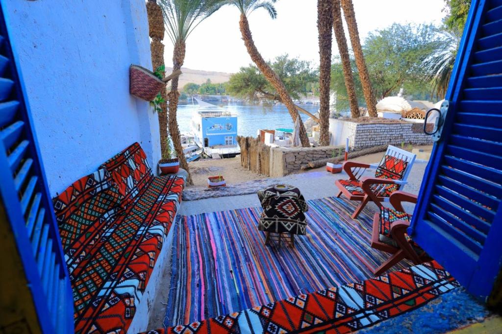 阿斯旺Nubian studio的一个带椅子和地毯的庭院,享有水景