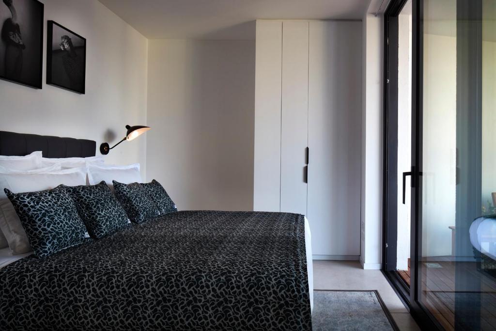 特拉维夫Renoma Apartments的一间卧室配有黑色的床和一盏灯