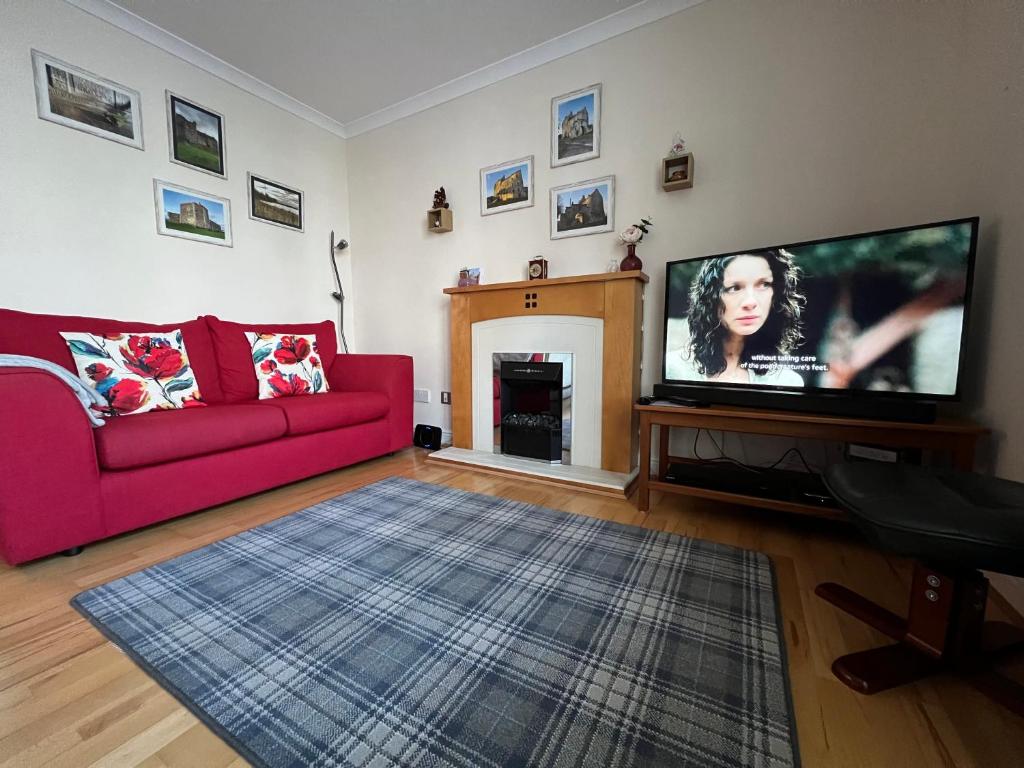 爱丁堡Old town, free parking, Outlander experience的客厅配有红色沙发和平面电视