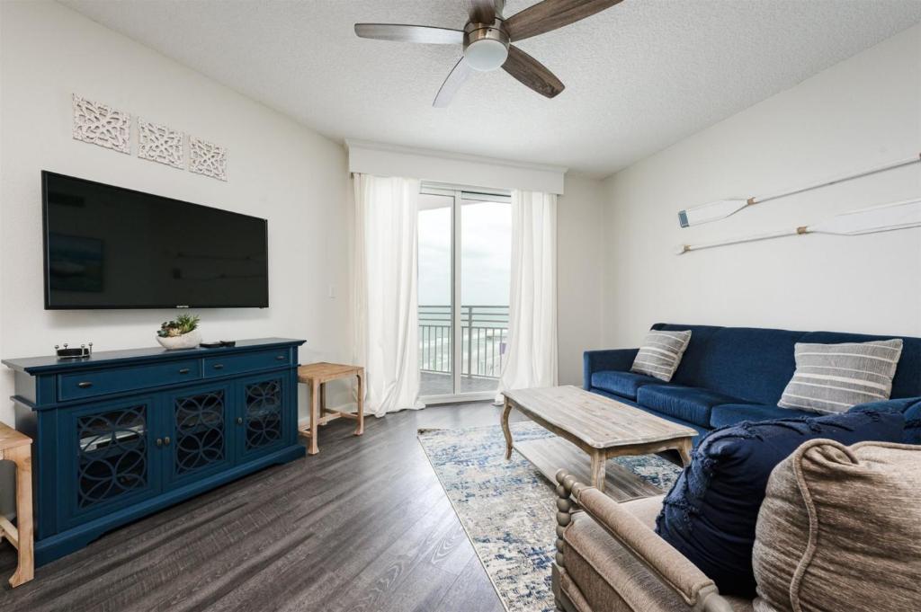 代托纳海滩Unit 2320 Ocean Walk - 2 Bedroom Ocean View的客厅配有蓝色的沙发和平面电视。