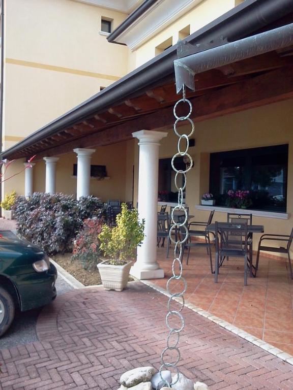 Azzano Decimo阿尔普提科酒店的挂在带庭院的建筑上的链条