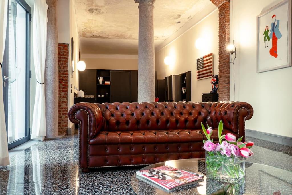 米兰Luxury Loft near Duomo and Garage的客厅里一张棕色的皮沙发,配有桌子