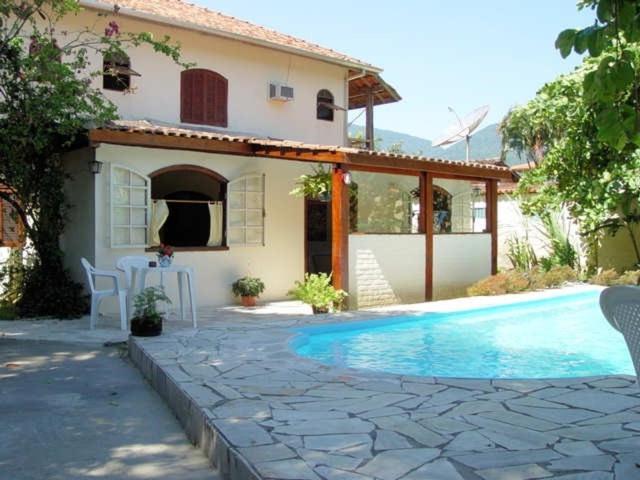 伊利亚贝拉Casa com 6 Suites, piscina e estacionamento的房屋前有游泳池的房子