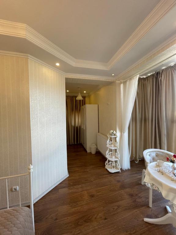 奥托佩尼Ami Residence Bucharest Airport,Therme&FREE PARKING Otopeni的客厅设有一张桌子,客厅设有白色的大房间。