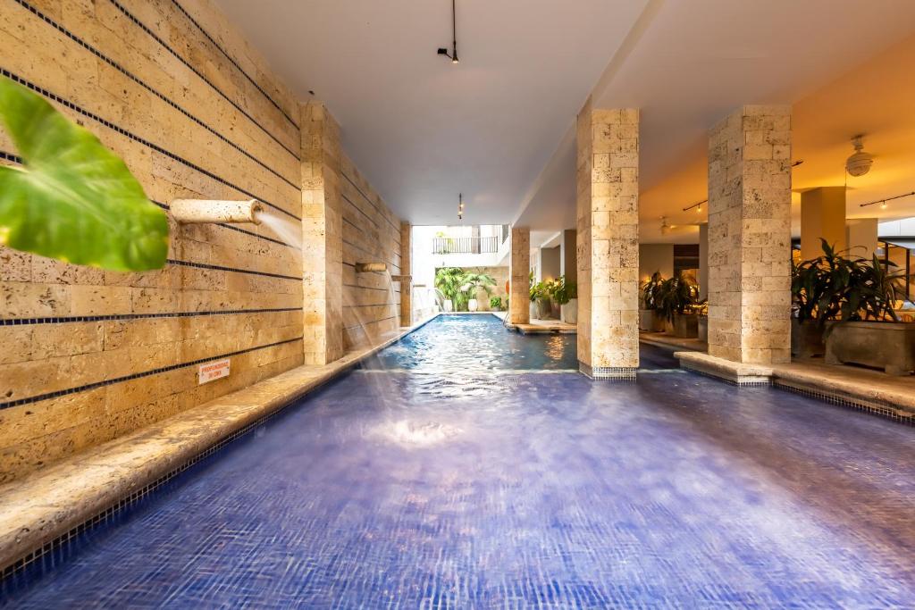 卡塔赫纳Madisson Boutique Hotel Cartagena的一个空的游泳池,地板上铺有蓝色的瓷砖