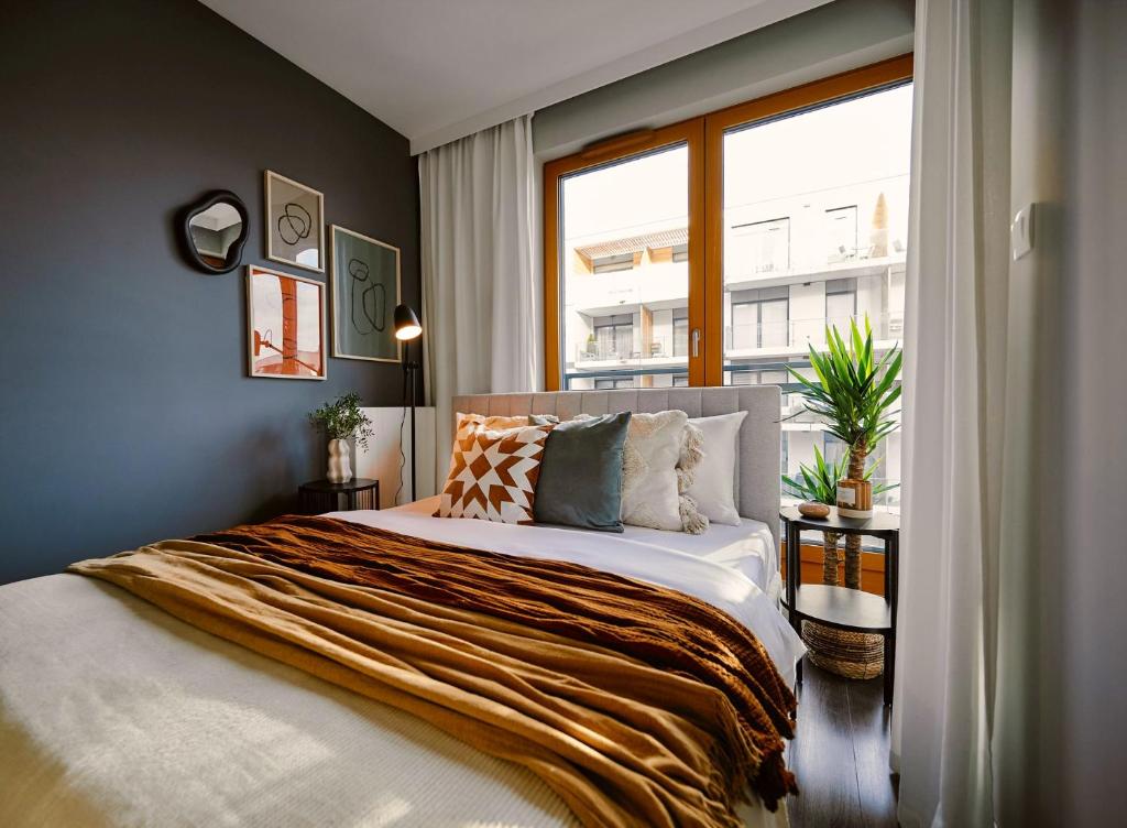 克拉科夫Przytulny Apartament Greenwall的一间卧室设有一张大床和窗户