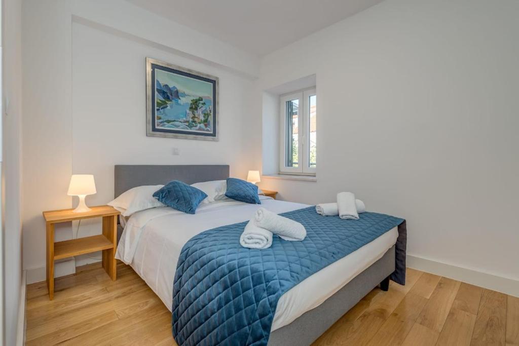 斯普利特贝尔维德公寓酒店的一间卧室配有一张带蓝色棉被的床