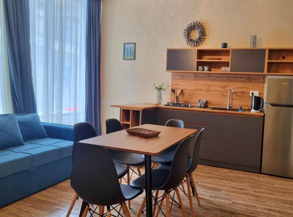 巴库里阿尼Greenfield Bakuriani的厨房以及带桌子和蓝色沙发的客厅。
