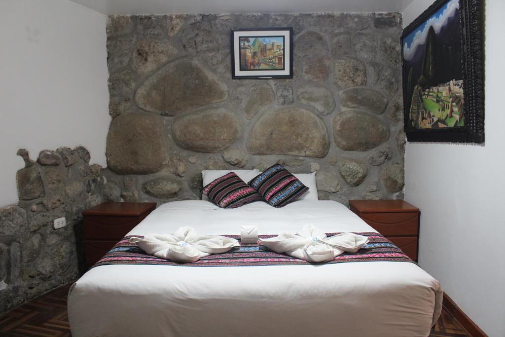 库斯科Hostal Turistico ILLAPA CUSCO 119的一间卧室配有一张石墙床