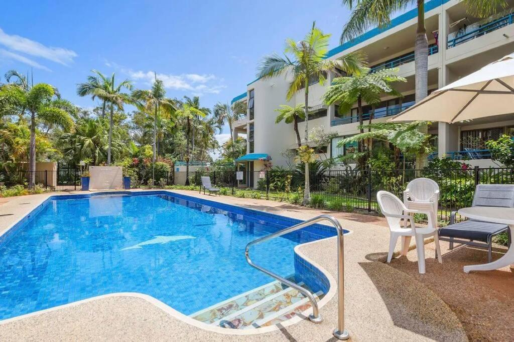 邦加里Our Beach House in Bribie Island的一座带椅子的游泳池以及一座建筑