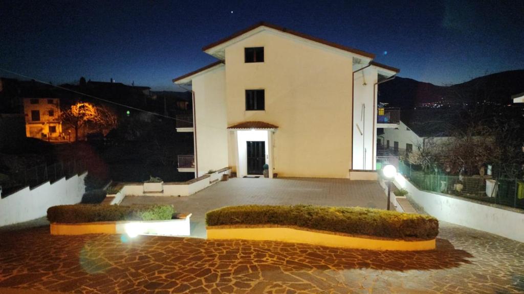 科皮托Dimora del CAMMINATORE的一座白色的大建筑,晚上有庭院