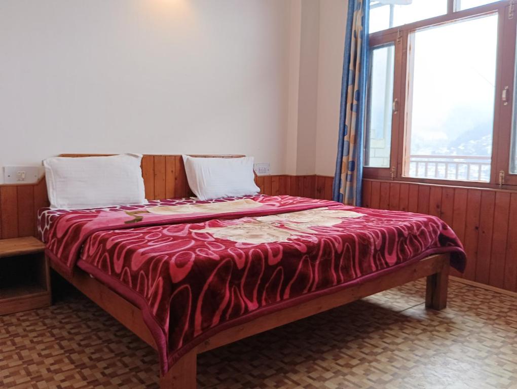 马拉里ROOP MOUNTAIN HOMESTAY的一张床上的床上,上面有红毯