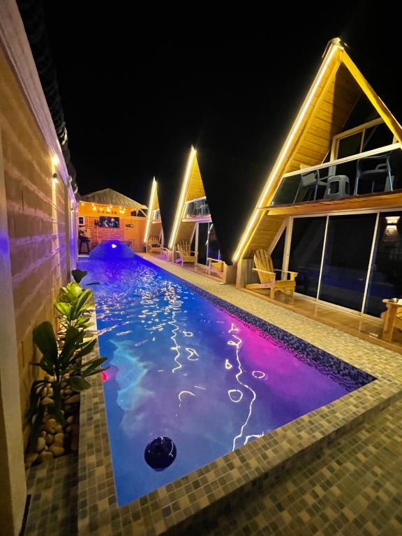 佩德纳莱斯Villa completa confotable para 9 personas的夜间房子中间的一个游泳池