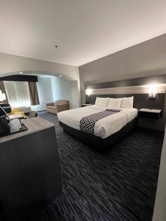艾伦艾伦拉昆塔乡村套房酒店的酒店客房设有一张大床和一张书桌。