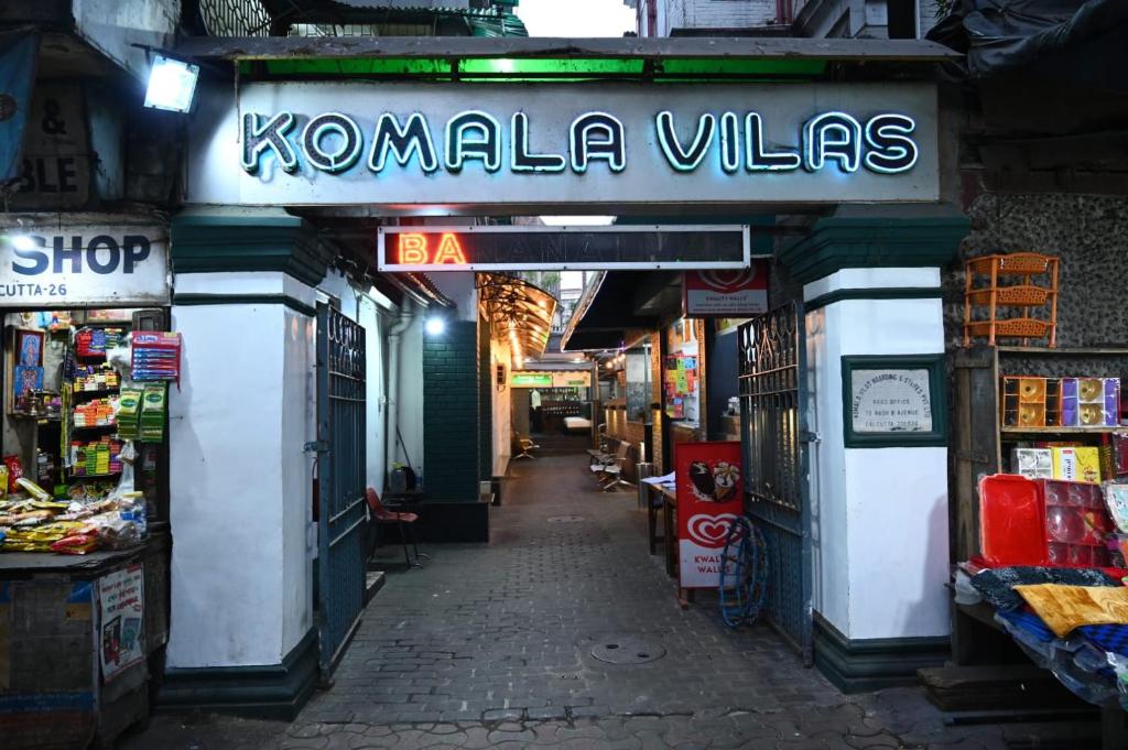 加尔各答Hotel Komala Vilas的一家商店,上面有读卡马勒村的标语