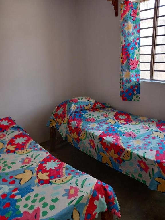平圭Bibi Mrembo Guesthouse的配有彩色床单的客房内的两张床