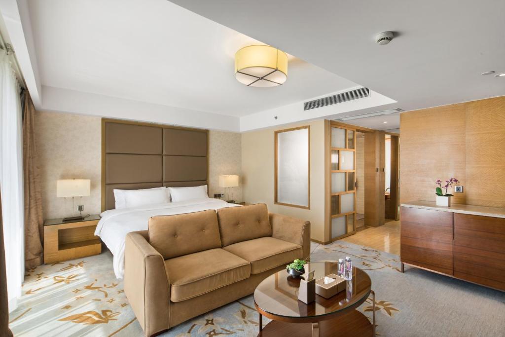 深圳The LA Hotel 新世界伟瑞酒店的酒店客房,配有床和沙发