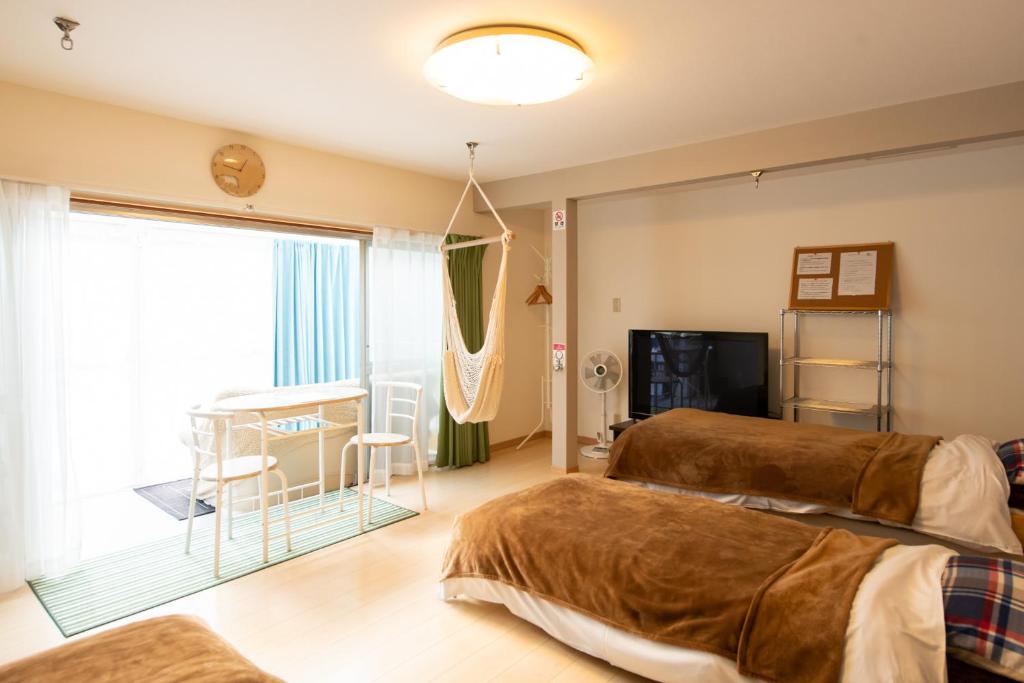 境港市境港命运旅馆的一间卧室设有两张床、一张桌子和一个窗口