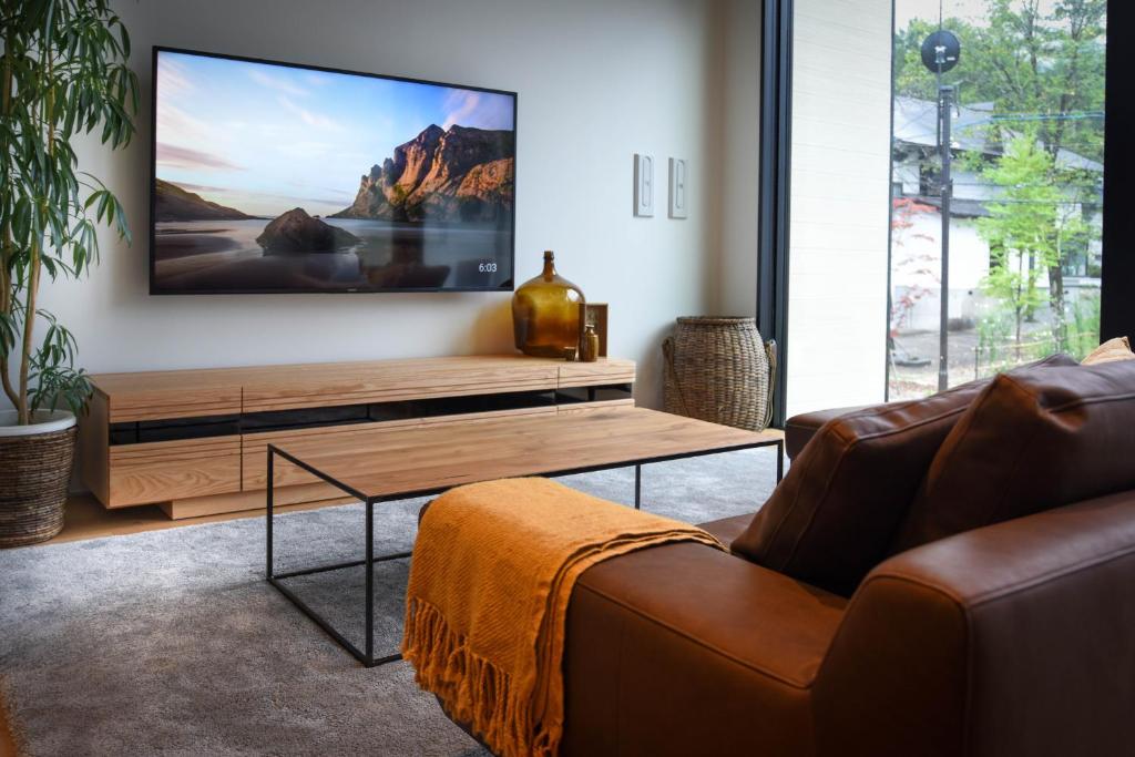 白马村Prominence by The Hakuba Collection的带沙发和平面电视的客厅