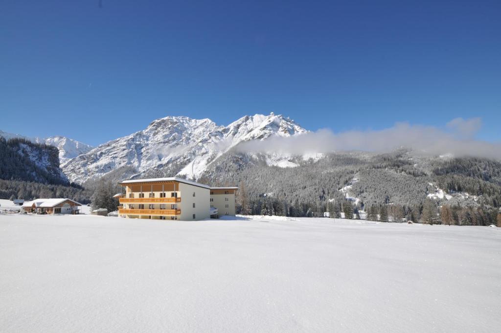 布拉伊埃斯爱斯贝尔酒店的一座位于雪地覆盖的山地的建筑