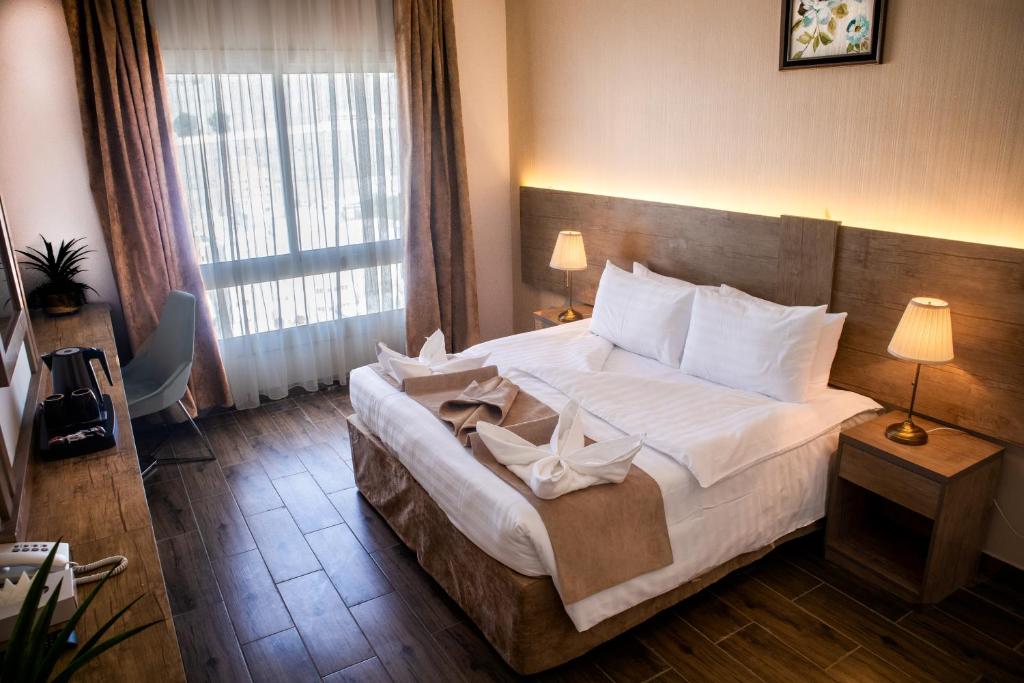 麦加Emaar Legend的卧室配有一张带白色床单和枕头的大床。