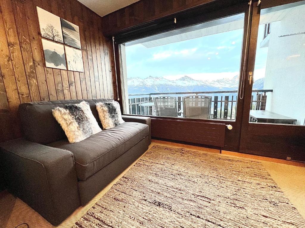 莱斯克伦斯Cosy Studio for 5 near ski lift, Les Gentianes的带沙发和大窗户的客厅