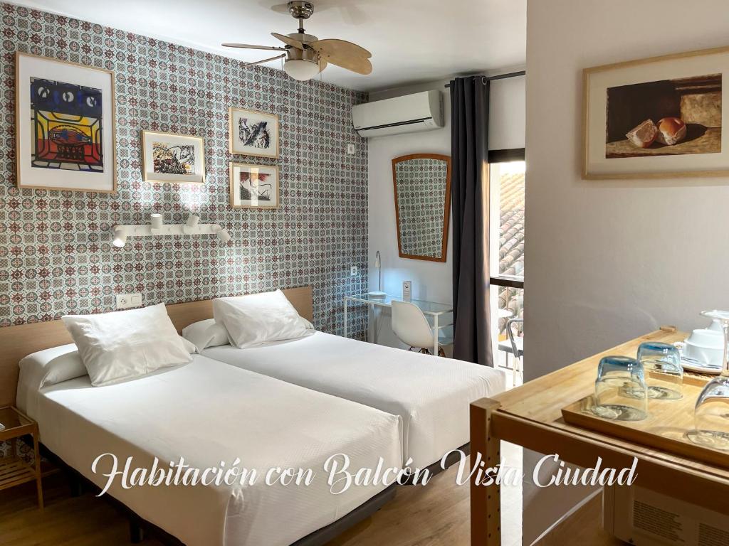 多列毛利诺斯Beatriz Charming Hostal的一间卧室配有一张床、一张桌子和一个窗户。