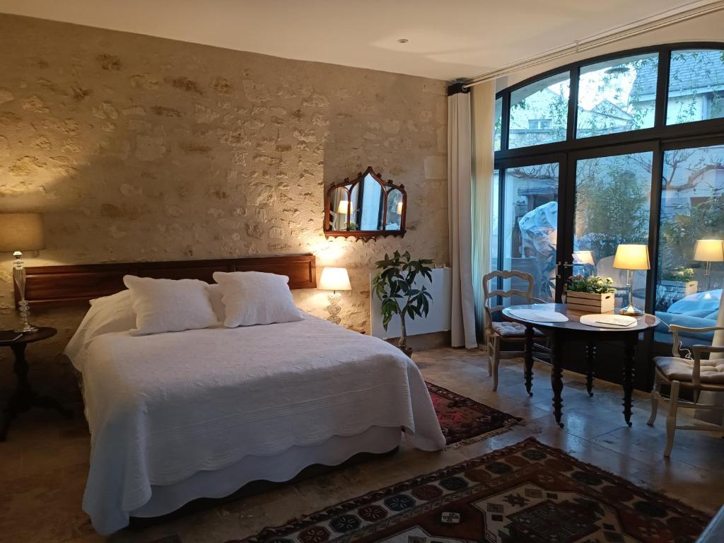 希农Gîte la comète的卧室配有一张白色的大床和一张桌子