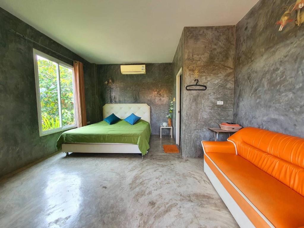 北冲北冲版衫理南度假村的一间卧室设有一张绿色的床和一个窗户。