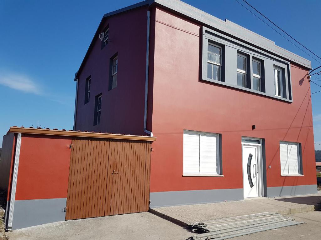 穆希亚Casa Campaña的一座红色和橙色的建筑,设有车库