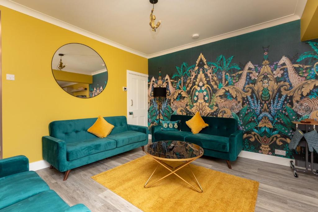 达特福德OnSiteStays - Stylish 4 BR House with Beautiful Outdoor Space, Wi-Fi & Smart TVs的客厅配有蓝色的沙发和镜子