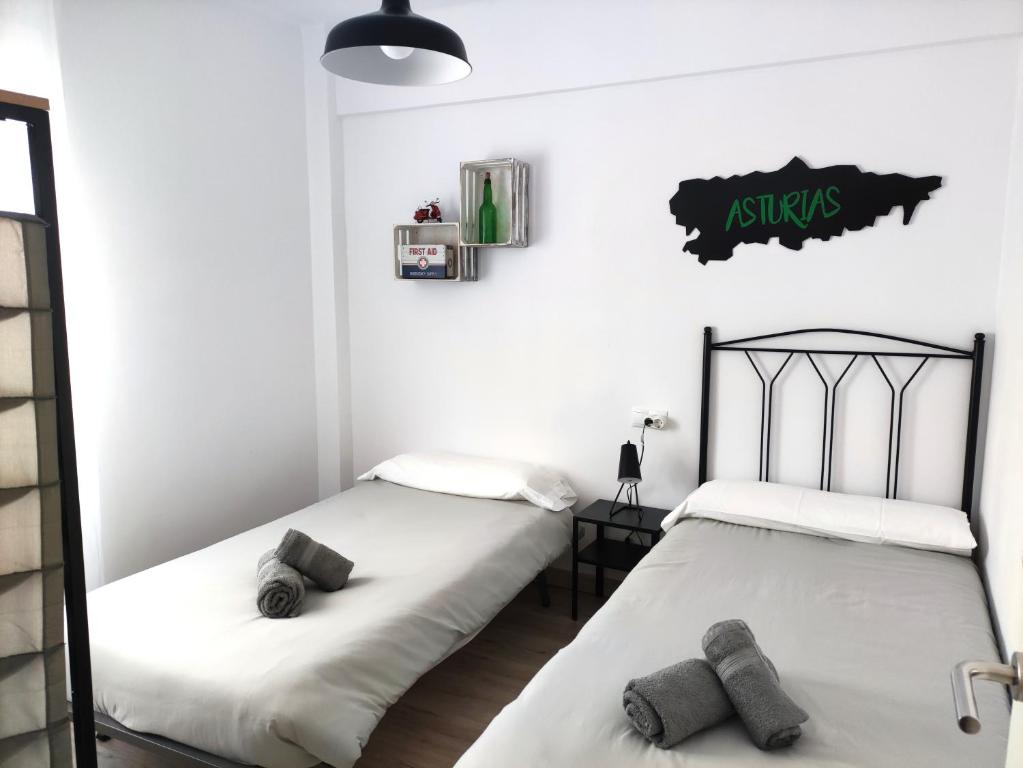 希洪Apartamento Casa Aurelio的两张睡床彼此相邻,位于一个房间里