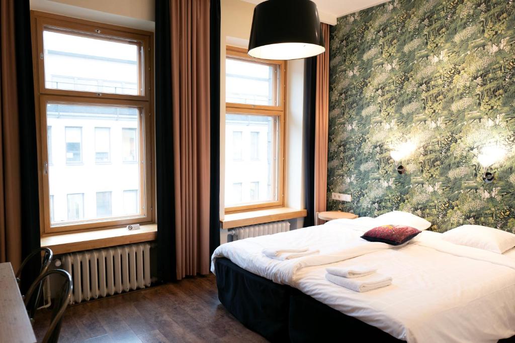 赫尔辛基费恩酒店的一间卧室设有一张床和两个窗户。