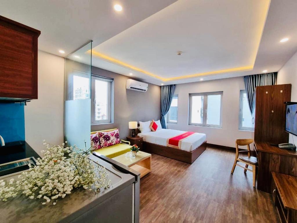 岘港Delicate Serviced Apartment And Hotel的酒店客房设有床和客厅。