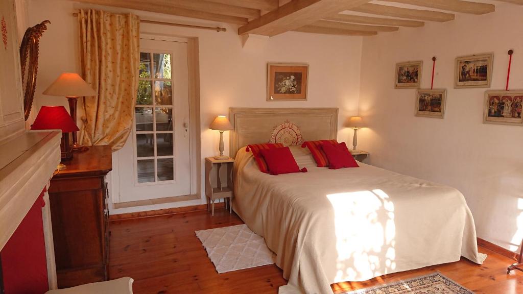 吉维尼A l'Ombre du Tilleul的一间卧室配有一张带红色枕头的床