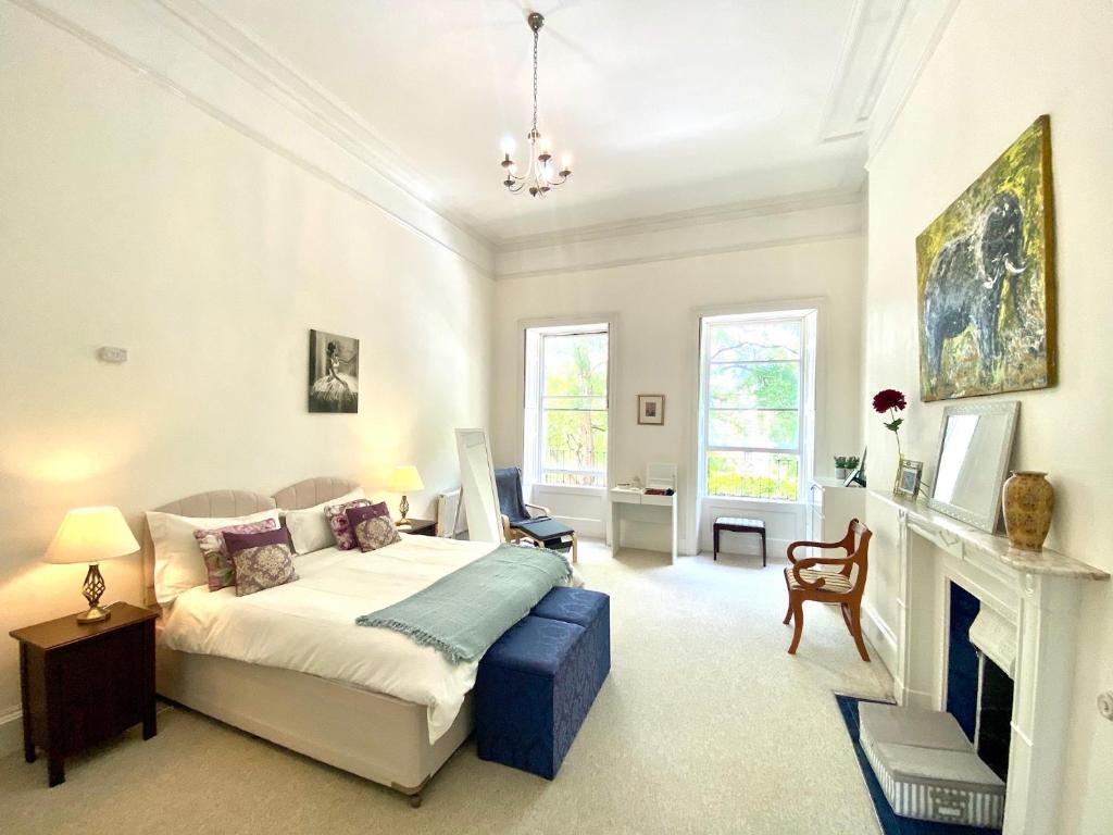 巴斯Grosvenor Apartments in Bath - Great for Families, Groups, Couples, 80 sq m, Parking的一间卧室配有一张床和一个壁炉