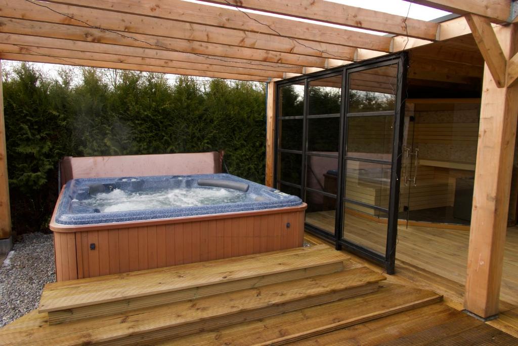 泽沃德Luxurious Family Villa with swimmingpool big garden and jacuzzi的木甲板上的热水浴池