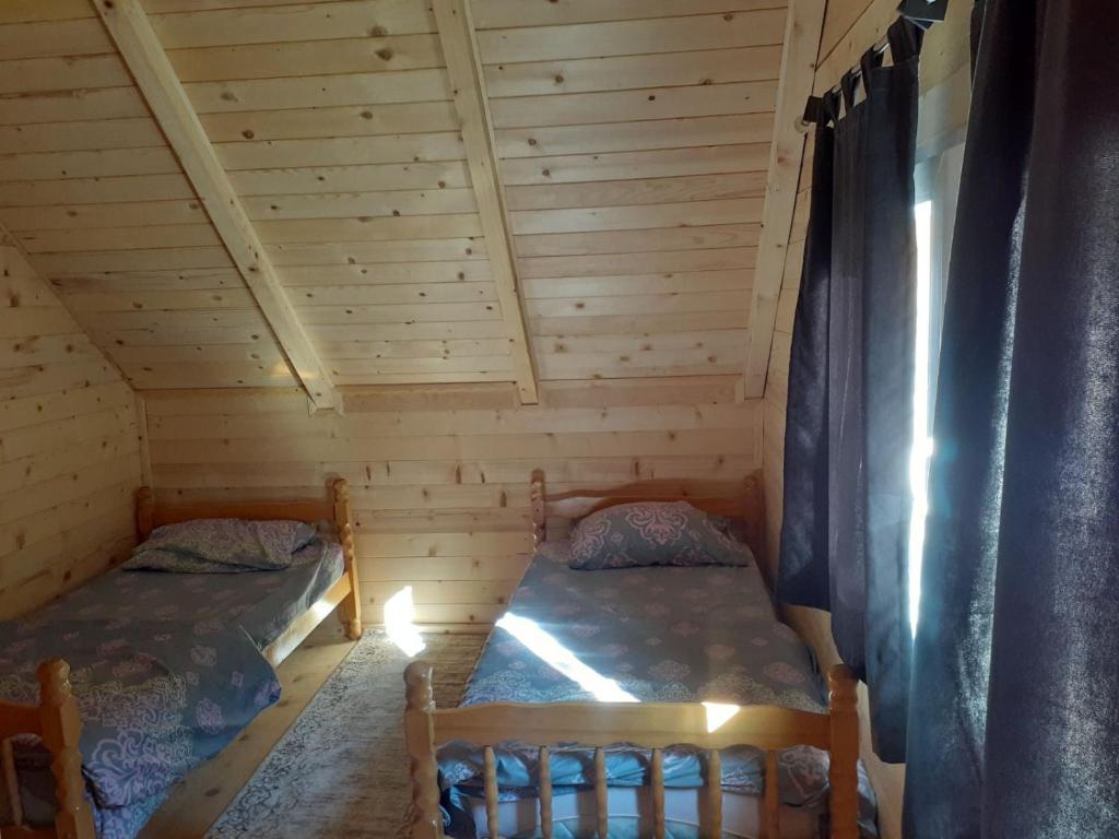 佩奇Villas Meti Rugove的小木屋内带两张床的房间