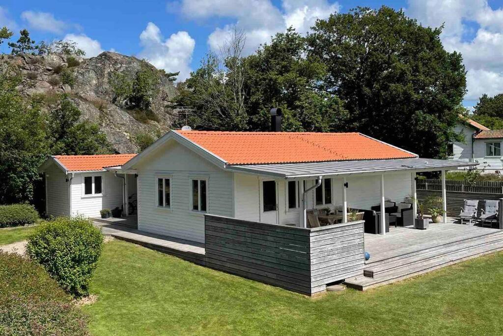莫勒松德Trevligt hus & Sjöbod i mysiga Mollösund Tången的一座白色的小房子,拥有橙色的屋顶