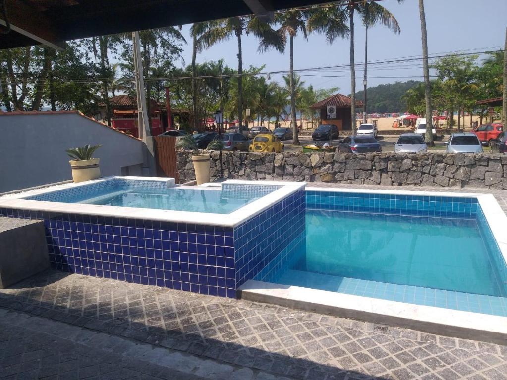 卡拉瓜塔图巴Santa Paula - Cocanha - De frente para a Praia的地面上一个蓝色瓷砖的游泳池