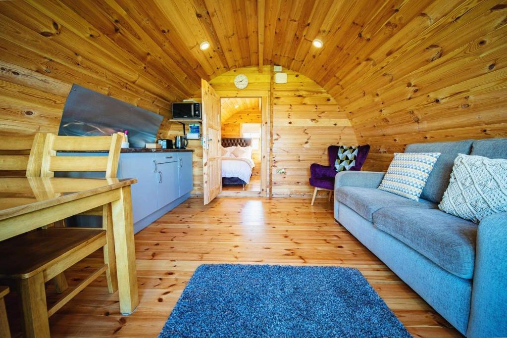 巴利卡斯尔Ceide Glamping的小木屋内的客厅配有蓝色沙发