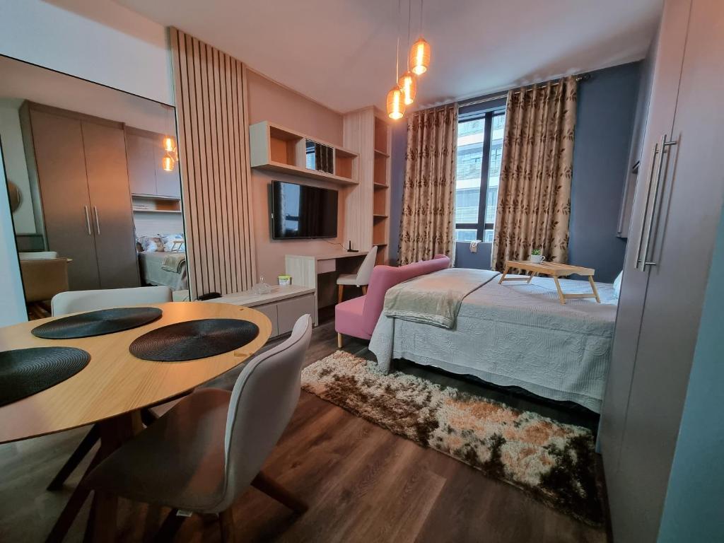 巴鲁埃里Flat luxo, mobiliado c/ ar, wi-fi, pisc. e academia的卧室配有一张床和一张桌子及椅子