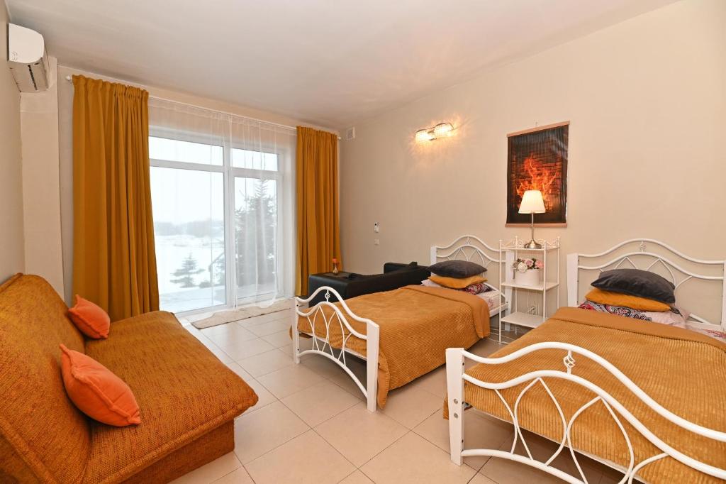 NemėžisMS Resort的一间带两张床和一张沙发的客厅