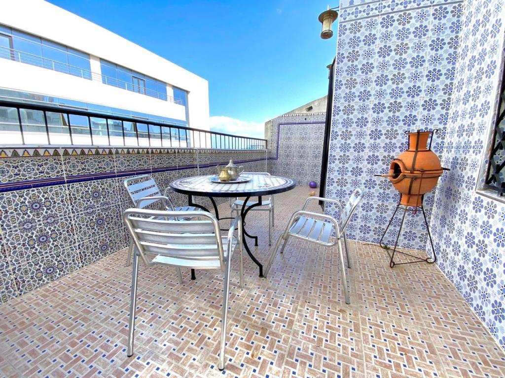丹吉尔Belle appartement vue sur mer的阳台的天井配有桌椅