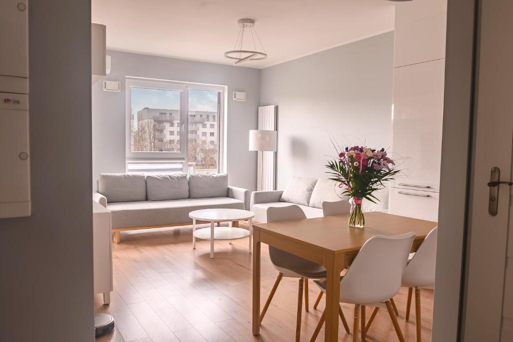 华沙Marywilska apartment的客厅配有桌子和沙发